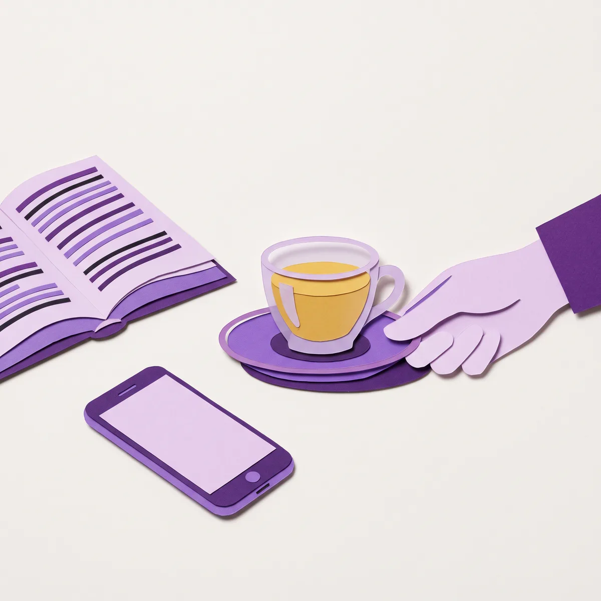 A hand setting down a glass of tea beside an open book and a phone.